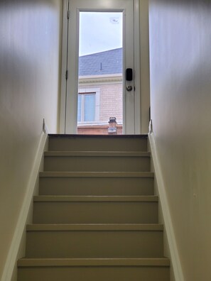 Un escalier menant à une porte qui donne sur un bâtiment situé à l’extérieur.