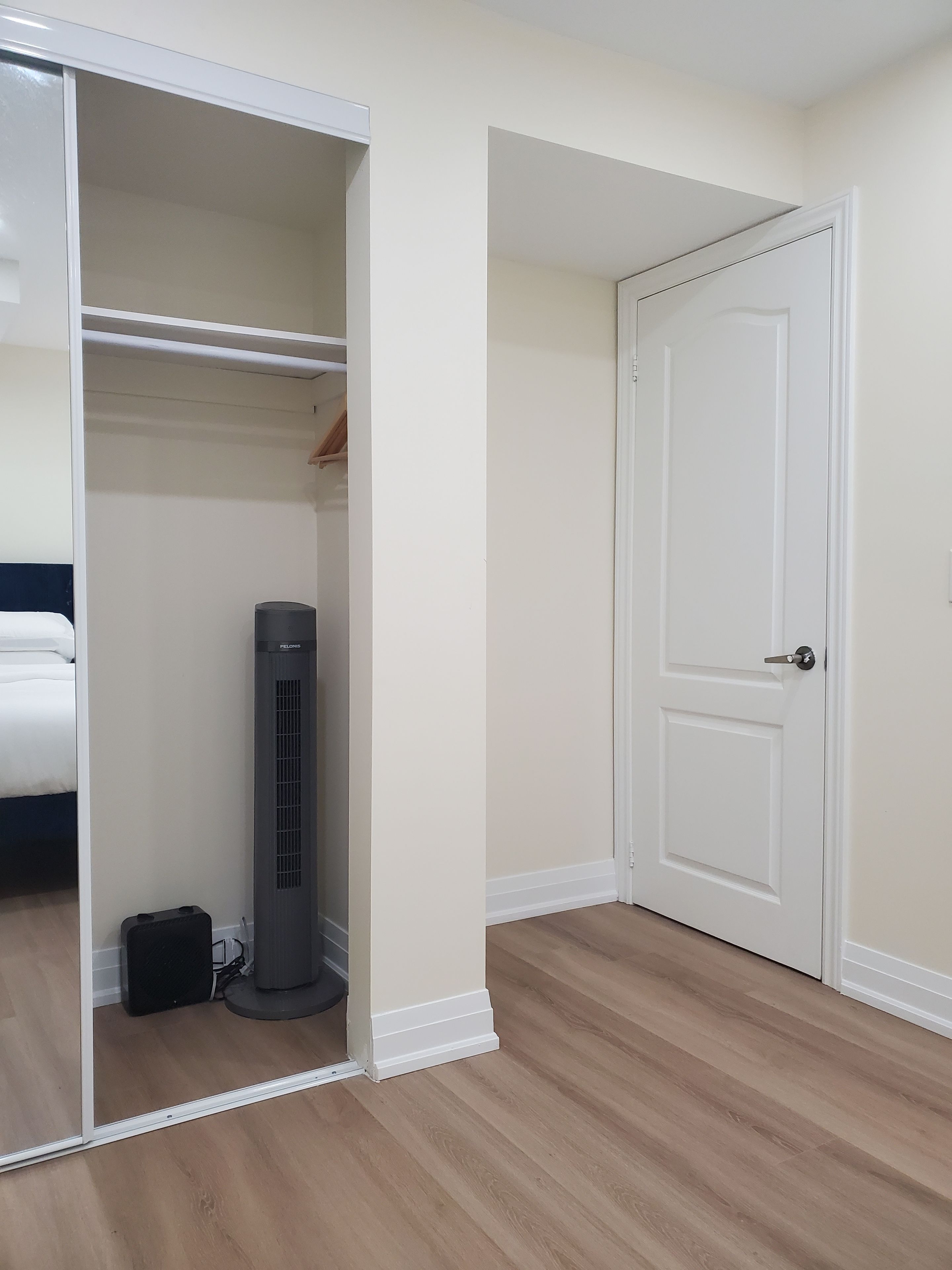 Une pièce comprenant un lit, une armoire, un radiateur et une porte.
