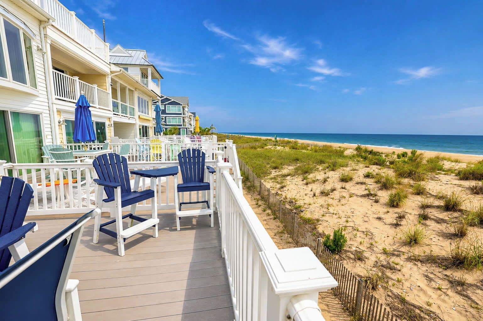 Une propriété située en bord de mer, dotée d’une terrasse, de chaises et de tables.