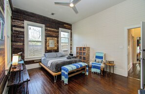 Ein Schlafzimmer mit Bett, Bank, Stuhl und einem kleinen Tisch.