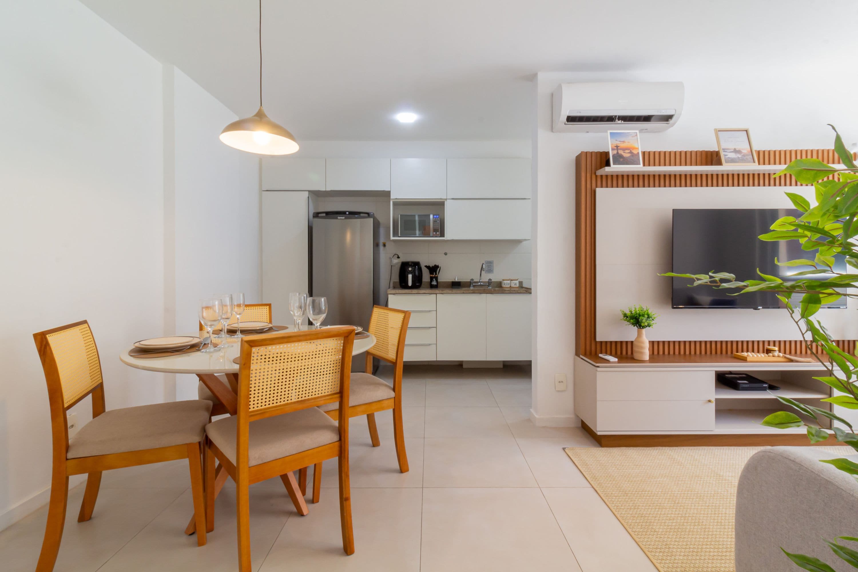A modern kitchen with white cabinets, a stainless steel refrigerator, and a microwave.