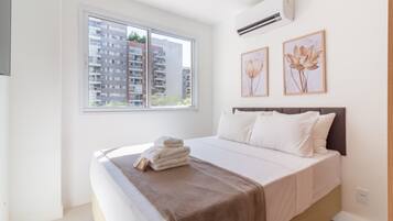 Ein Schlafzimmer mit einem Bett, einem Fenster und zwei Wandklimaanlagen.