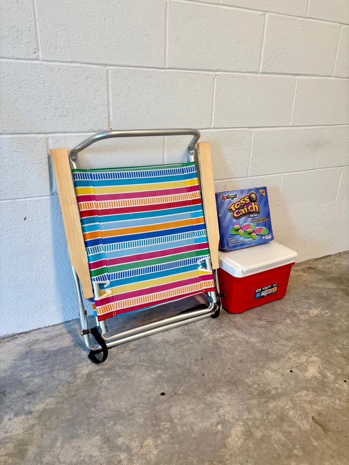 A colorful striped fabric item on a metal stand, a red storage box, and a package labeled 'Trixie Catch.'