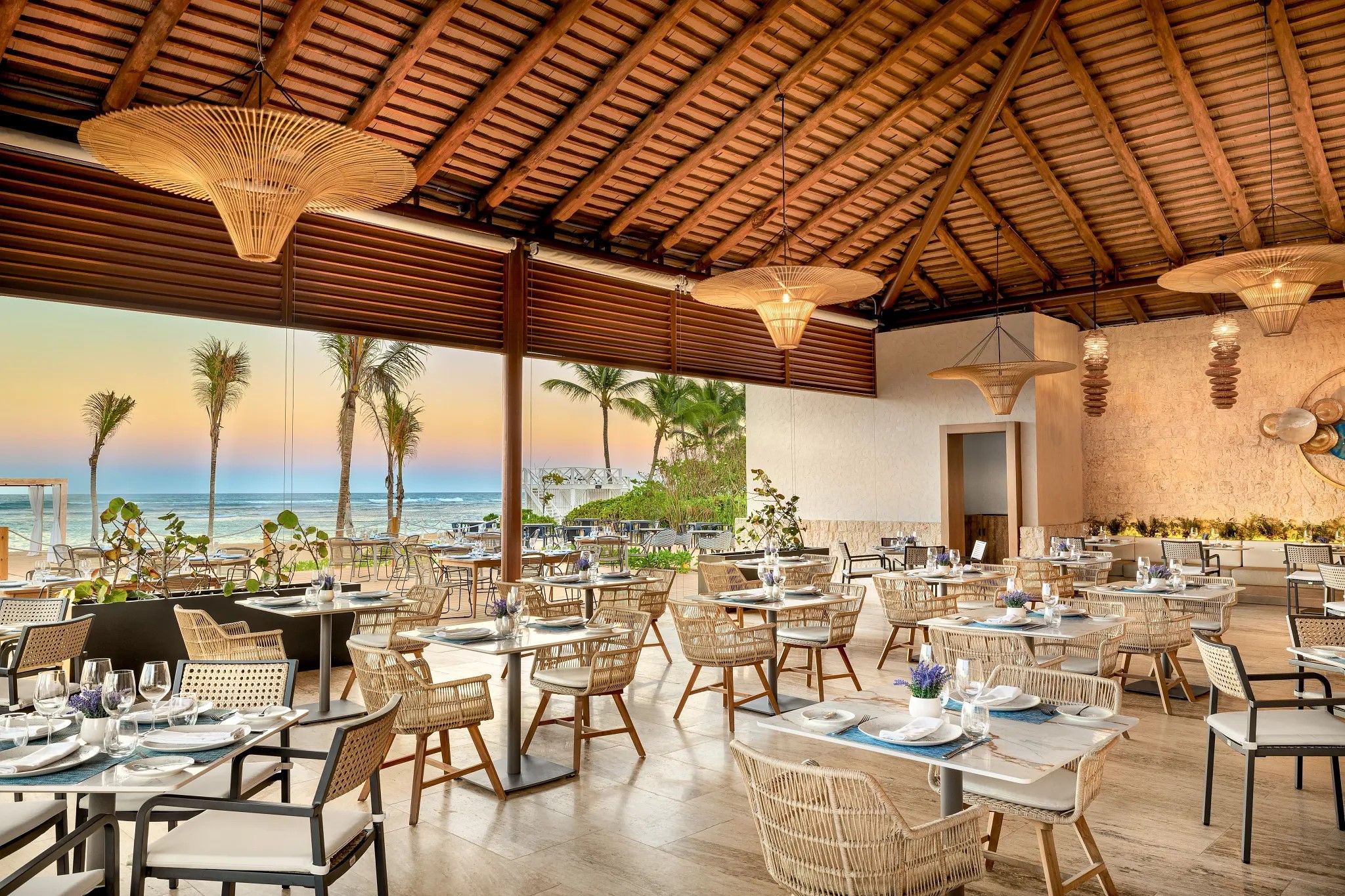 An outdoor dining area with tables and chairs, overlooking the ocean.