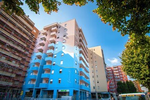 Un edificio a più piani con un design architettonico originale, caratterizzato da balconi e un mix di colori.