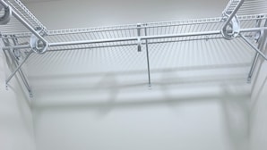 Un placard avec des étagères en métal et un plancher en bois.