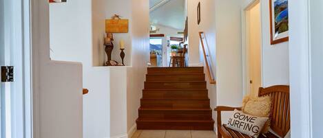 A staircase leading to a dining area with a bench and a cushion with text.