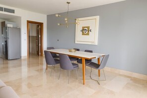 A dining area with a table, chairs, and a pendant light. - Luxury Condo in La Amada | Private Beach and Resort (Q.R.)