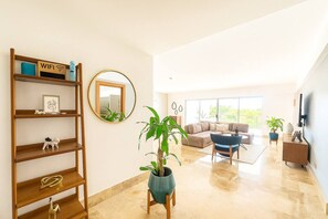 Un salon moderne avec un canapé, une table basse et une plante en pot.