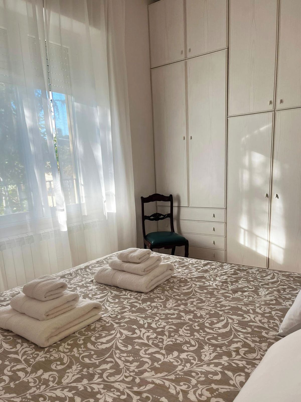 Une chambre à coucher avec un lit, une chaise et une armoire.
