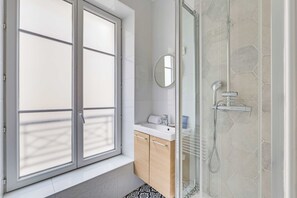 A bathroom with a window, a mirror, a sink, and a shower. - Bright Studio 2P - Louvre / Palais Royal (Paris)