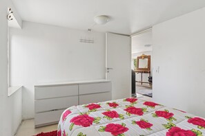 Une chambre à coucher avec un lit, une commode et un miroir.