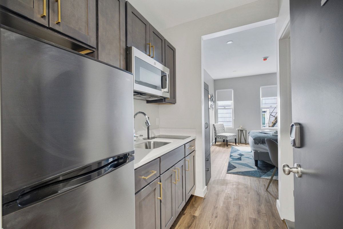 A modern kitchen with stainless steel appliances, a microwave, and a sink.