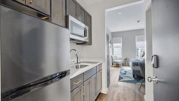 A modern kitchen with stainless steel appliances, a microwave, and a sink.