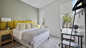 A bedroom with a bed, bedside tables, a desk, and a chair. - The Columbus Hotel - The Residence Studio - 89-206 (Middletown)