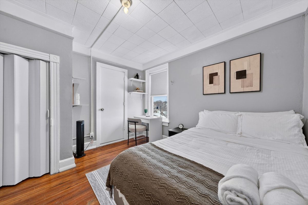 Quarto com cama, escrivaninha e cadeira.