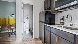 Eine moderne Küche mit dunklen Schränken, einem Edelstahlkühlschrank und einer doppelten Spüle.