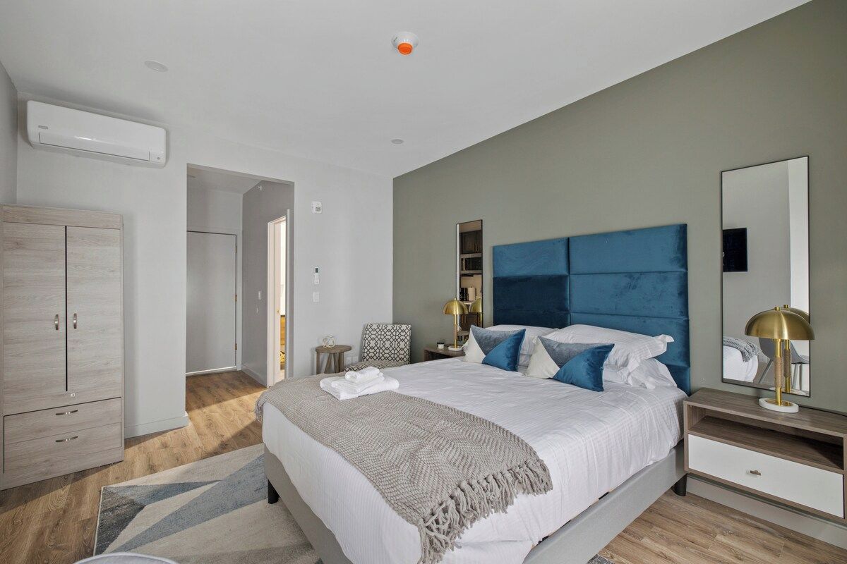 A bedroom with a bed, bedside tables, a wardrobe, and a mirror.