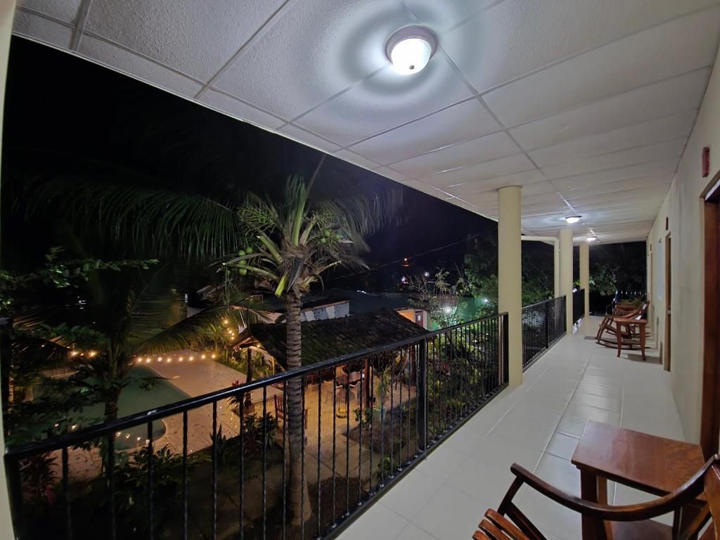 A balcony with a railing, a table, and chairs.