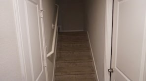 A carpeted staircase in a hallway with white walls and doors. - Houston Family-Friendly Retreat Stylish 3BR Stay for Groups & Getaways (Houston)