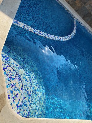 A swimming pool with mosaic tile patterns and a curved edge. - 5 bedrooms | Heated pool | Movie theater | Pool table - CASA ISELA (Cuernavaca)