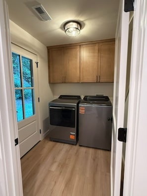 A compact kitchen with wooden cabinets, a built-in oven, and a refrigerator. - MOUNTAINSTEAD 3BD Glenville-Cashiers Farmhouse Big views creek waterfall donkeys (Glenville)
