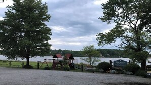 A playground with swings and a slide, a sign reading 'Winchester,' and a body of water in the background.