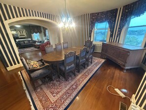 A dining area with a round table, chairs, and a patterned rug.