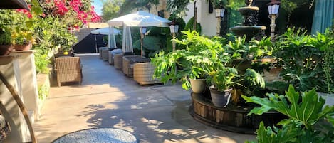 A courtyard with outdoor seating, a fountain, and potted plants.