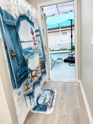 A door with a nautical-themed design, leading to a pool area with lounge chairs and umbrellas. - Tremendous 4-bedroom house with AC in charming Kissimmee (Kissimmee)