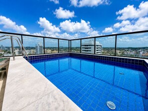 A rooftop swimming pool with a clear view of the cityscape.