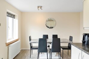 A dining area with a round mirror, a table, and six chairs. - Easy Edinburgh Access, Parking,Near Rosslyn Chapel (Midlothian)