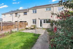 A two-story residential building with a paved patio and a small garden area. - Easy Edinburgh Access, Parking,Near Rosslyn Chapel (Midlothian)
