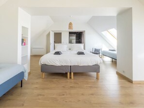 Un dormitorio con una cama grande, un escritorio pequeño y un tragaluz.