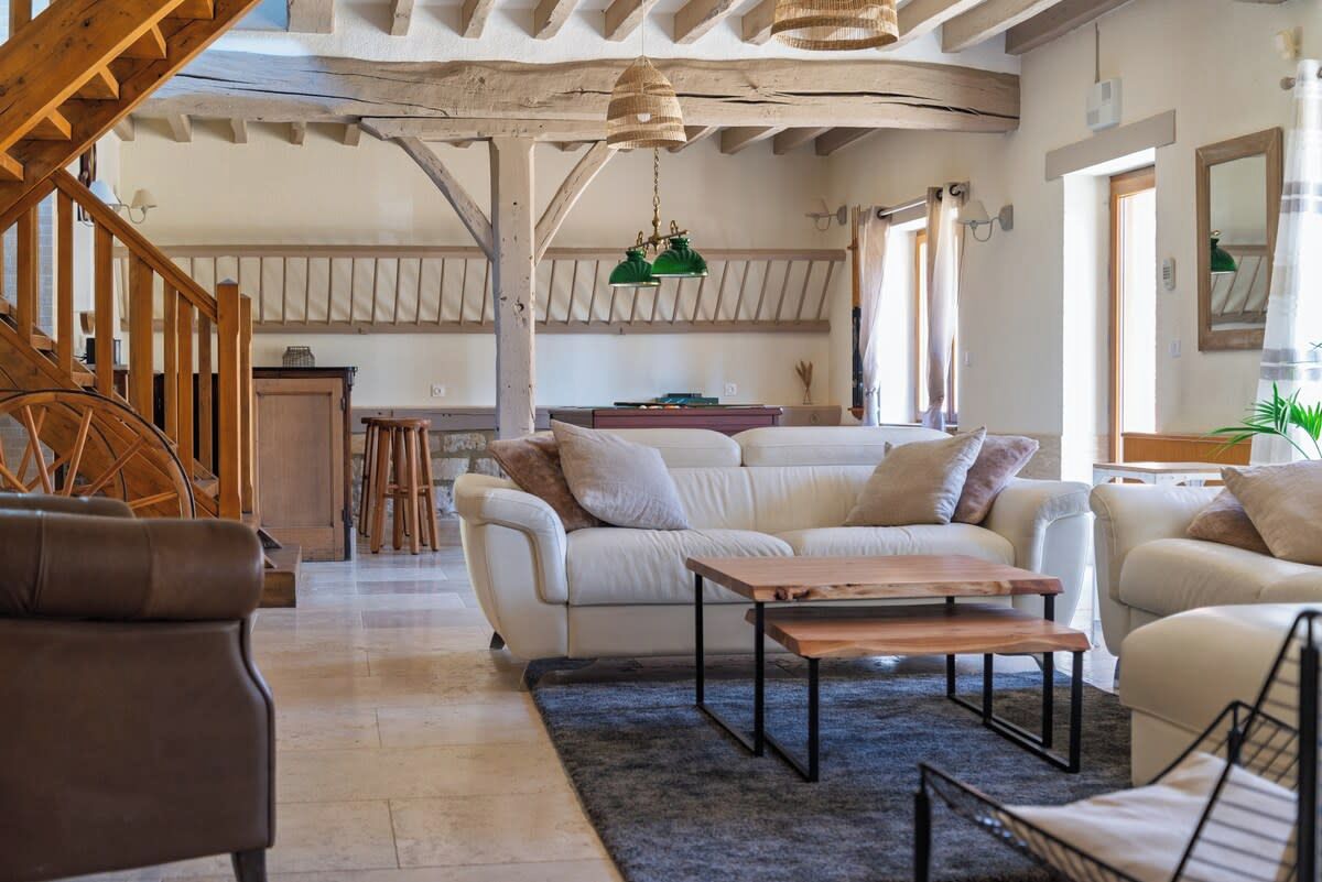 Ein großzügiger Wohnbereich mit Sofa, Couchtisch und Treppe.