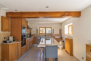Una cocina moderna con armarios de madera, una isla central y un horno empotrado.