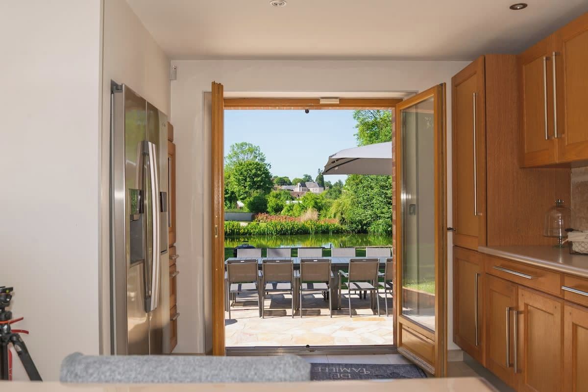 Une cuisine moderne donnant sur un patio avec jardin.