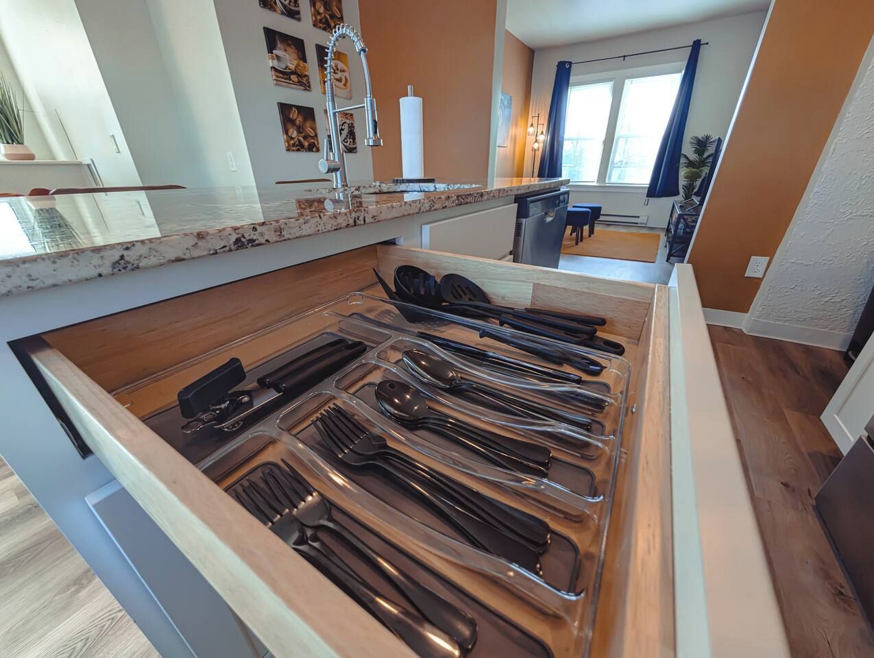 A kitchen with a drawer organizer containing various utensils.