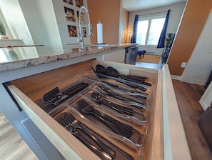 A kitchen with a drawer organizer containing various utensils. - Historic Detroit Charm • 10 min Downtown (Detroit)