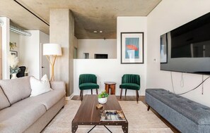 A modern living room with a sofa, two armchairs, a coffee table, and a flat-screen TV mounted on the wall. - Waterfront View 1bdrm Downtown, Free Parking, Next to Pier, Pike Place and Lumen (Seattle)