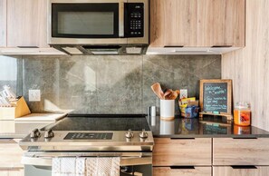 A kitchen with a stainless steel stove, a microwave, and a chalkboard sign. - Waterfront View 1bdrm Downtown, Free Parking, Next to Pier, Pike Place and Lumen (Seattle)