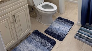 A bathroom with a toilet, sink, and a shower curtain.