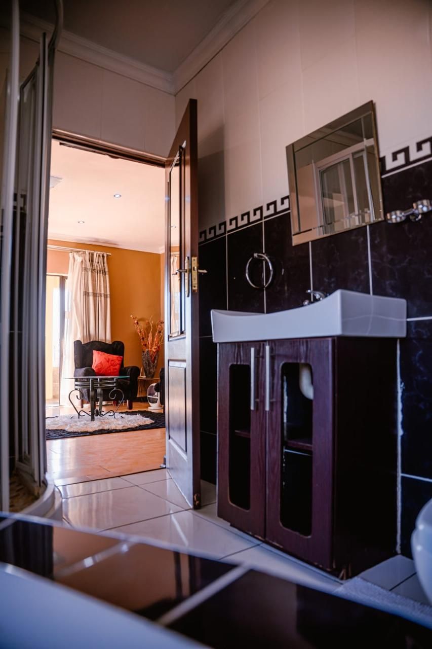 Habitación de hotel con baño que incluye tocador, espejo y zona de ducha.