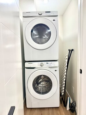A laundry room with two stacked washing machines and a drying rack. - Beautiful suite close to Spruce Meadows in Calgary, Canada (Calgary)