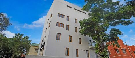A multi-story building with a flat facade, rectangular windows, and a visible entrance.