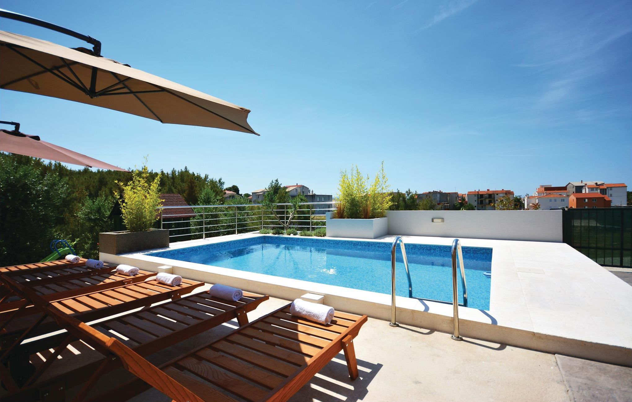 Une piscine sur le toit, dotée de chaises longues et d’une pergola.
