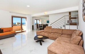 A spacious living area with a large sofa, a coffee table, and a dining area with chairs and a table. - Nice home in Podstrana with private swimming pool, can be inside or outside (Podstrana)
