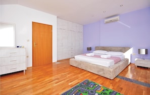 A bedroom with a bed, a wardrobe, a dresser, and an air conditioning unit. - Nice home in Podstrana with private swimming pool, can be inside or outside (Podstrana)