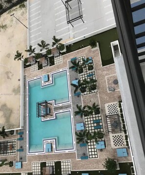 Vista aèria d'un hotel amb piscina central, diverses zones de relaxació i un aparcament.
