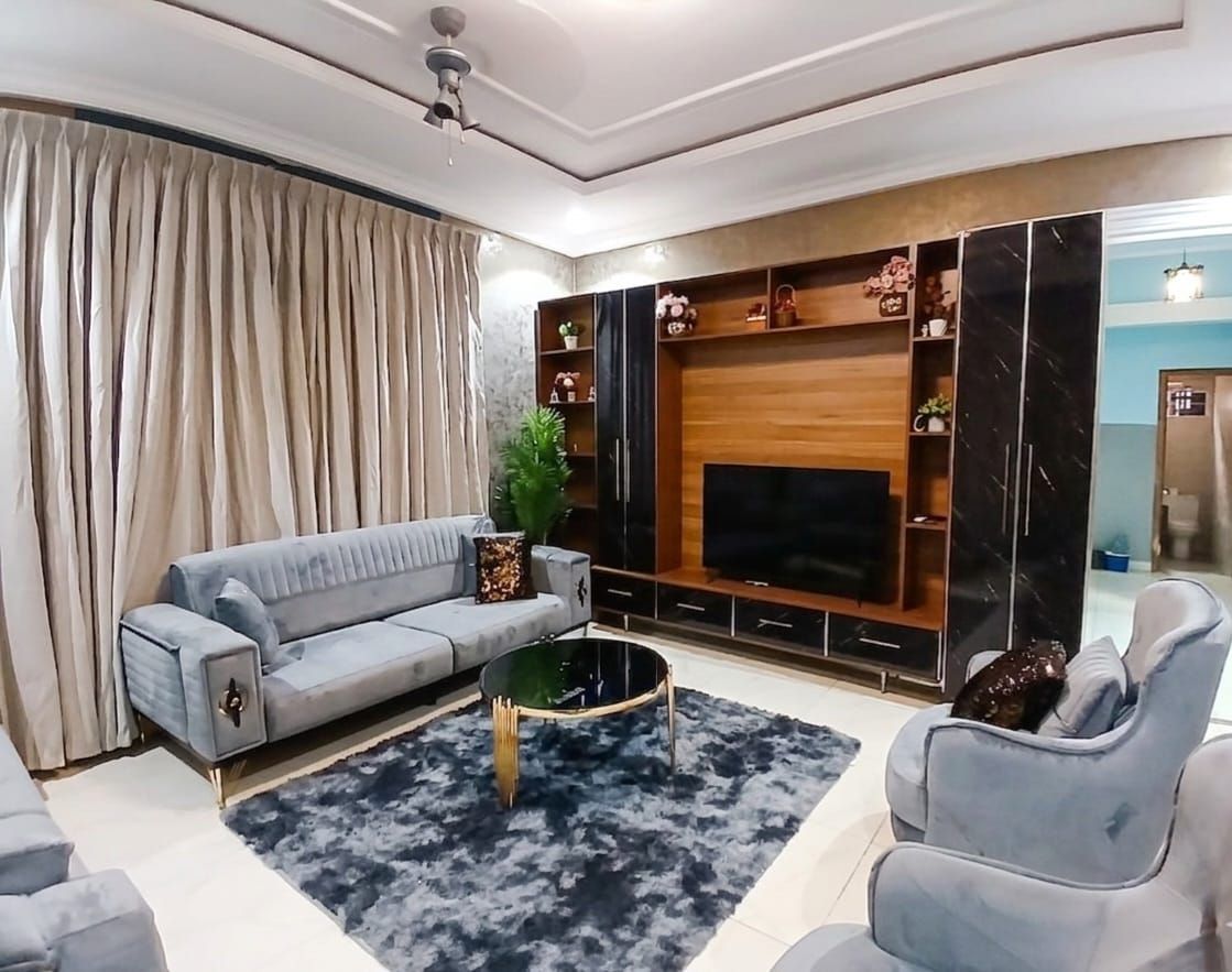 Una sala de estar con sofá, mesa de centro y mueble de entretenimiento.